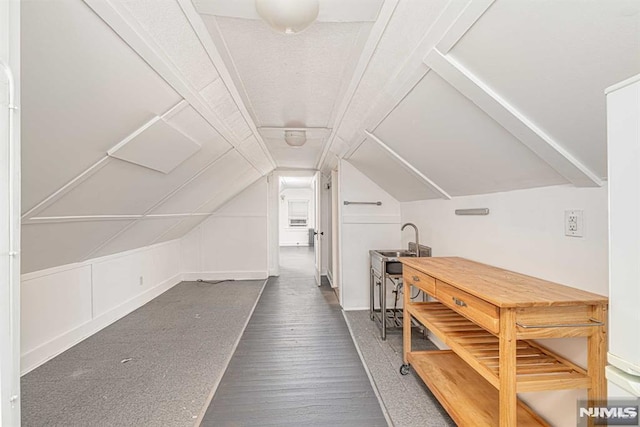 bonus room featuring dark hardwood / wood-style flooring, sink, and vaulted ceiling