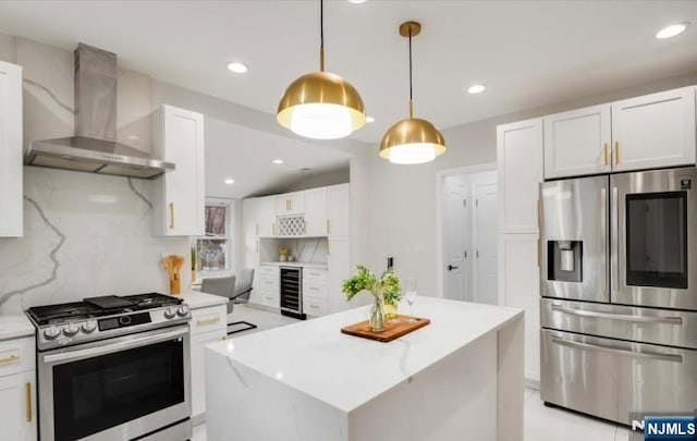 kitchen featuring white cabinetry, wine cooler, a center island, stainless steel appliances, and wall chimney exhaust hood