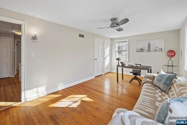 living room with light hardwood / wood-style flooring and ceiling fan