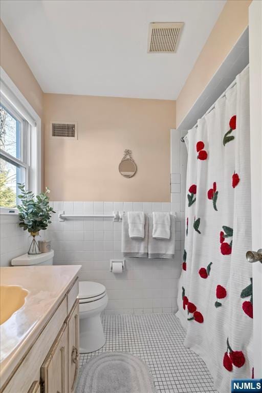 bathroom with tile walls, vanity, a shower with curtain, tile patterned floors, and toilet