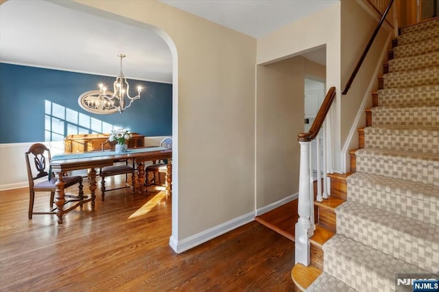 dining space with hardwood / wood-style flooring and an inviting chandelier