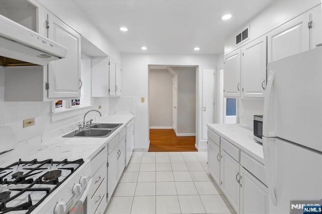 kitchen with white cabinetry, sink, white appliances, and light tile patterned flooring