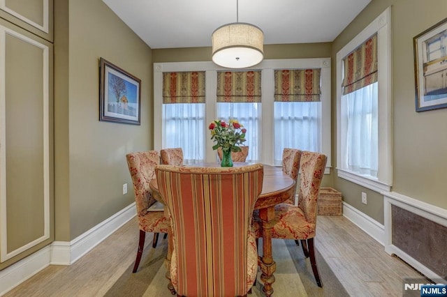 dining area featuring a wealth of natural light, light wood-type flooring, and baseboards