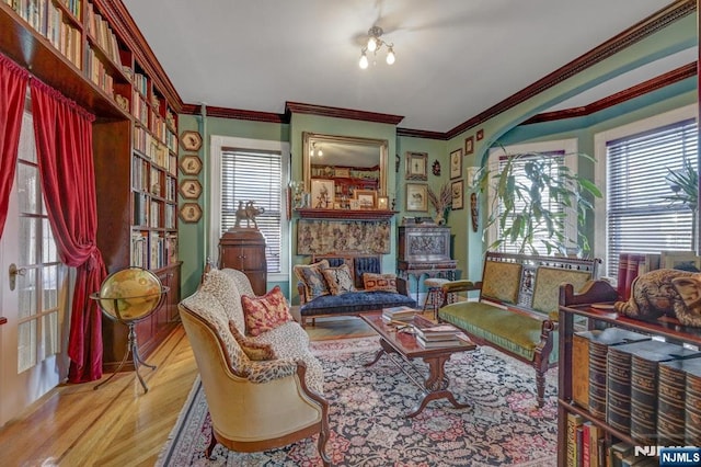 sitting room featuring ornamental molding and wood finished floors