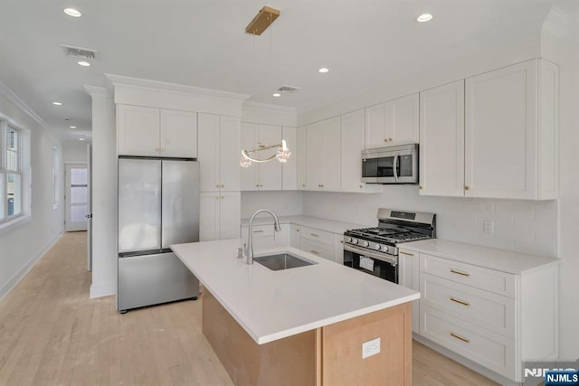 kitchen featuring white cabinetry, appliances with stainless steel finishes, sink, and a center island with sink