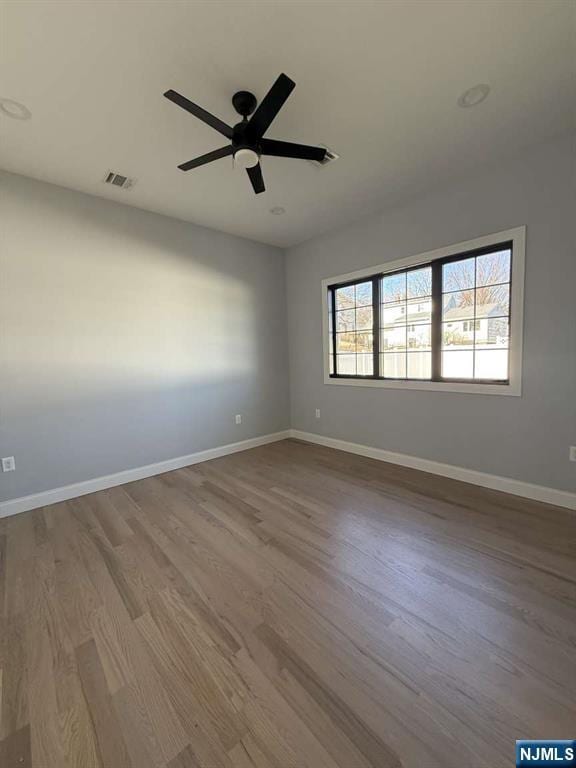 empty room with hardwood / wood-style flooring and ceiling fan