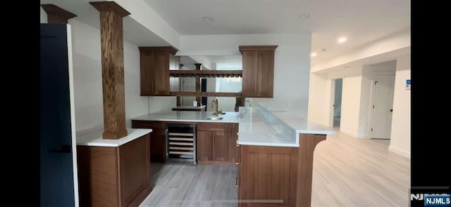 bar with sink, wine cooler, and light hardwood / wood-style floors