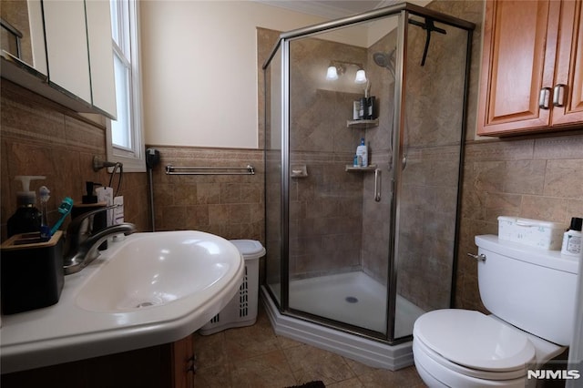 bathroom with sink, tile walls, tile patterned flooring, toilet, and walk in shower