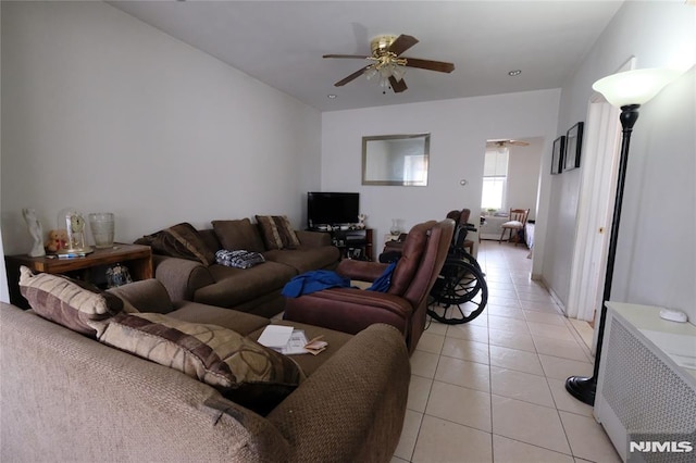 living room with radiator, light tile patterned floors, and ceiling fan