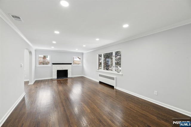 unfurnished living room with radiator, crown molding, and dark wood-type flooring