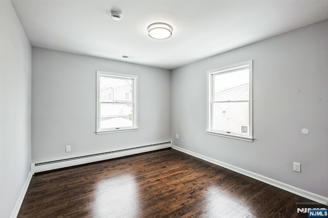 empty room featuring a baseboard radiator and dark hardwood / wood-style floors