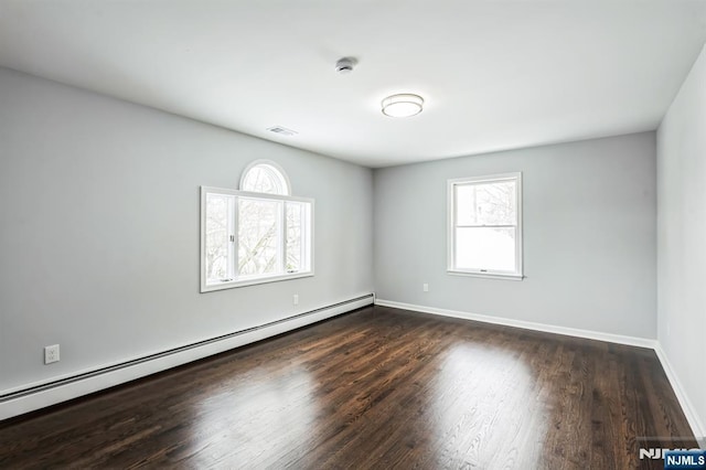 spare room with dark hardwood / wood-style flooring and baseboard heating