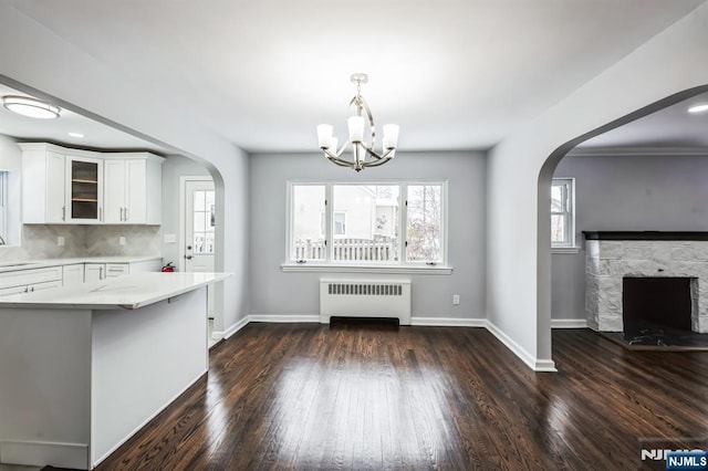 kitchen featuring white cabinetry, radiator, dark wood-type flooring, and kitchen peninsula