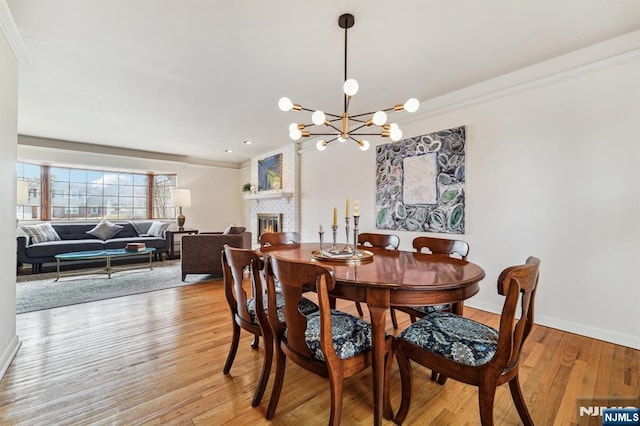 dining space with a notable chandelier, ornamental molding, baseboards, and hardwood / wood-style flooring