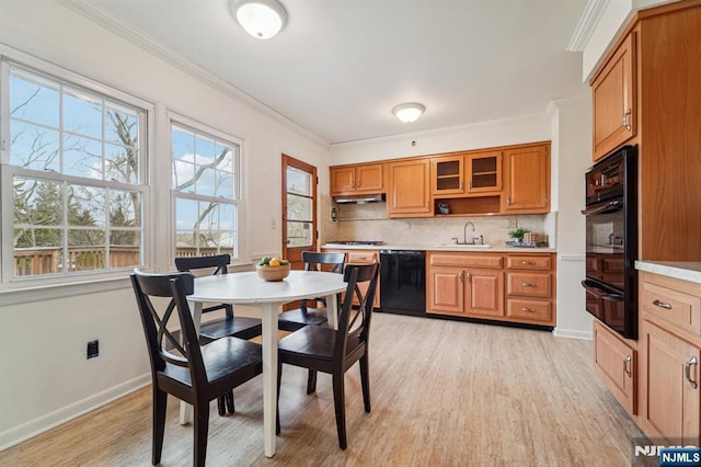 dining area featuring baseboards, light wood finished floors, and ornamental molding