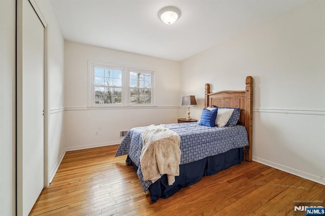 bedroom with visible vents, baseboards, and hardwood / wood-style floors