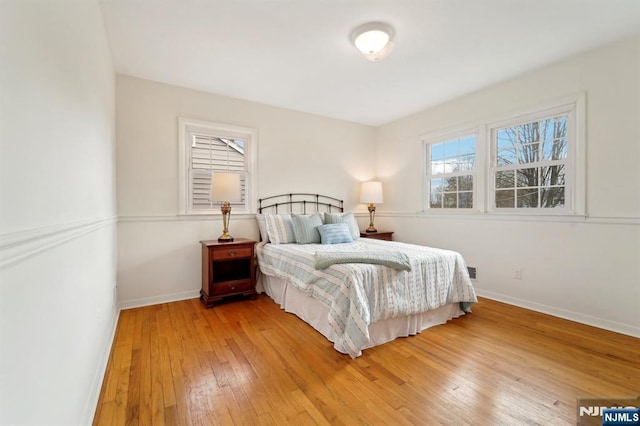 bedroom with light wood-style floors and baseboards