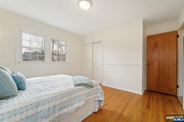 bedroom with a closet, baseboards, and light wood-style floors