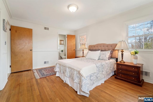 bedroom featuring hardwood / wood-style flooring, crown molding, and visible vents