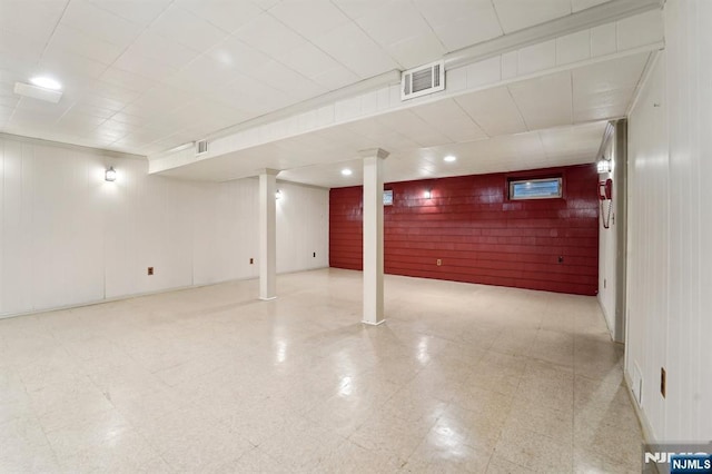 finished basement featuring tile patterned floors and visible vents