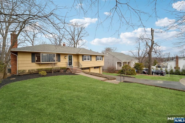 ranch-style house with a garage, driveway, a front lawn, and a chimney