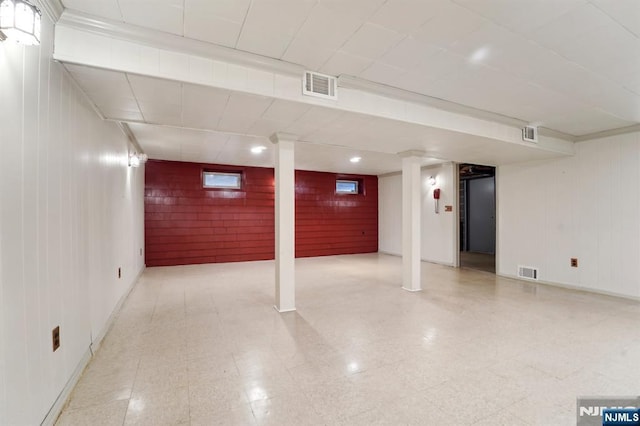 finished basement with tile patterned floors, baseboards, and visible vents