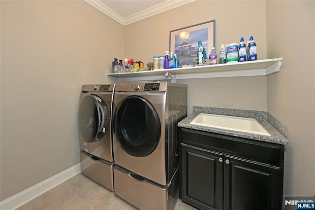 clothes washing area featuring sink, cabinets, light tile patterned floors, ornamental molding, and washer and clothes dryer