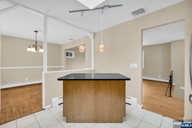 kitchen featuring light tile patterned floors, baseboard heating, and decorative light fixtures