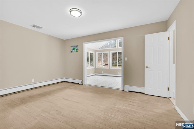 spare room with a baseboard radiator and light wood-type flooring