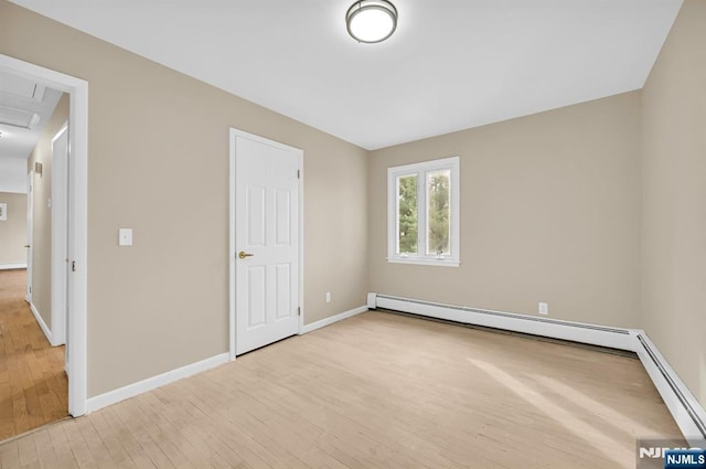 unfurnished bedroom with light hardwood / wood-style floors and a baseboard heating unit