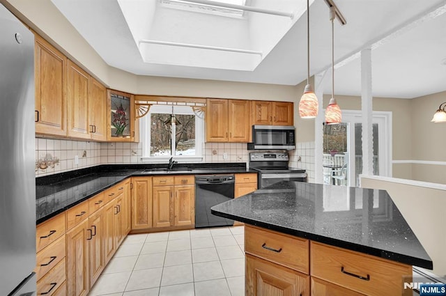 kitchen with sink, light tile patterned floors, dark stone countertops, appliances with stainless steel finishes, and decorative backsplash