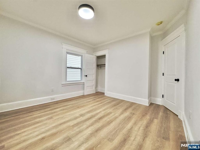 unfurnished bedroom with crown molding, a closet, and light hardwood / wood-style flooring