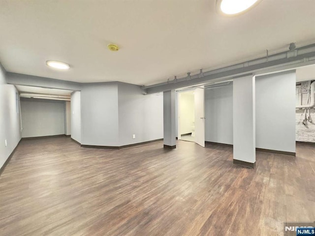 basement with dark hardwood / wood-style floors