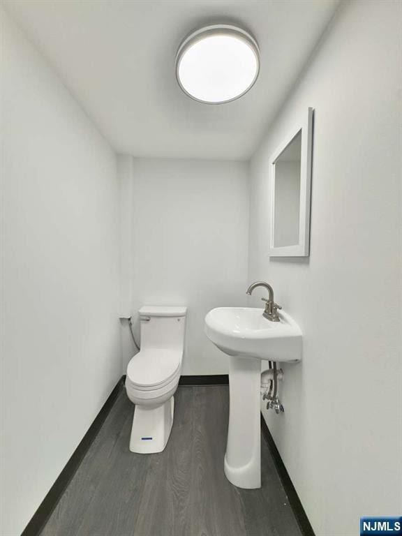 bathroom featuring wood-type flooring and toilet