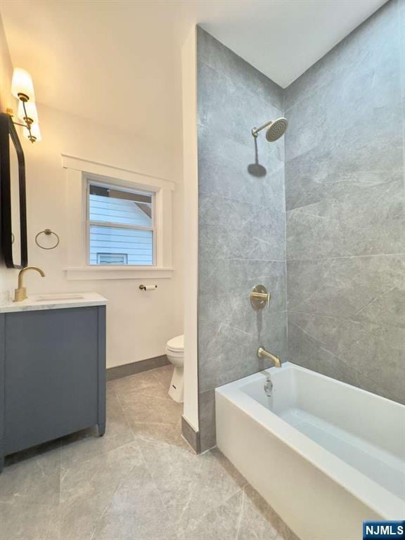 full bathroom featuring vanity, tiled shower / bath combo, and toilet