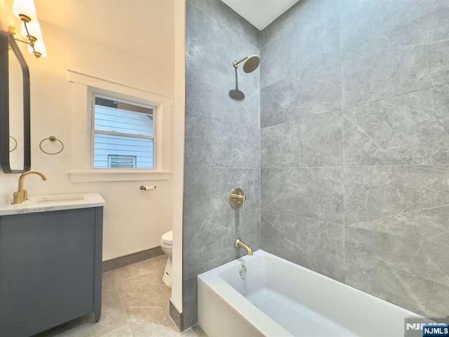 full bathroom with vanity, tiled shower / bath, tile patterned floors, and toilet