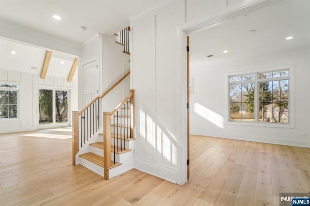 stairs featuring beam ceiling and hardwood / wood-style flooring