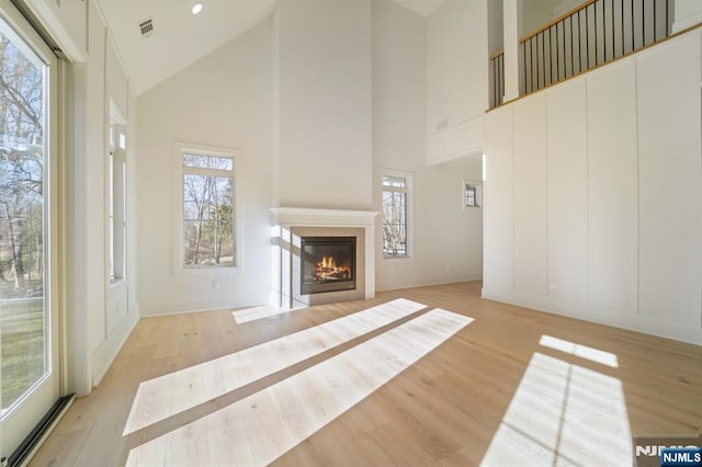 living room with high vaulted ceiling and light hardwood / wood-style floors