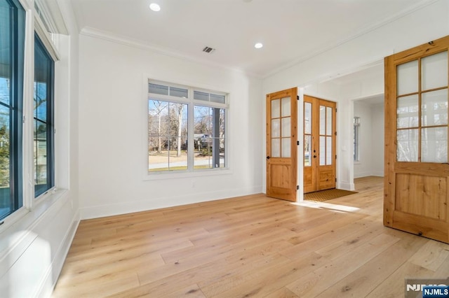 empty room featuring ornamental molding and light hardwood / wood-style floors