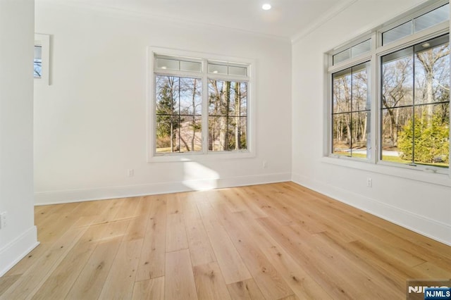 unfurnished dining area with crown molding, a wealth of natural light, and light hardwood / wood-style flooring