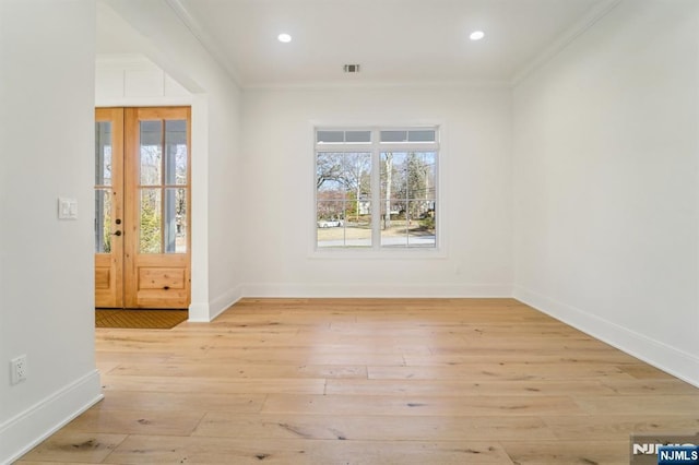 spare room featuring ornamental molding and light hardwood / wood-style floors