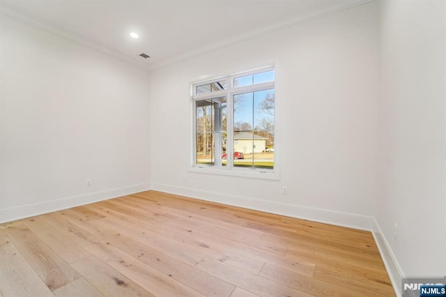 empty room featuring crown molding and light hardwood / wood-style floors