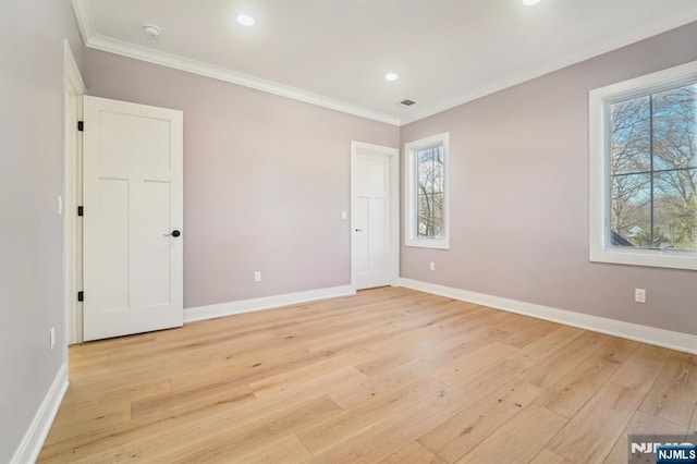 unfurnished bedroom with ornamental molding, multiple windows, and light hardwood / wood-style flooring