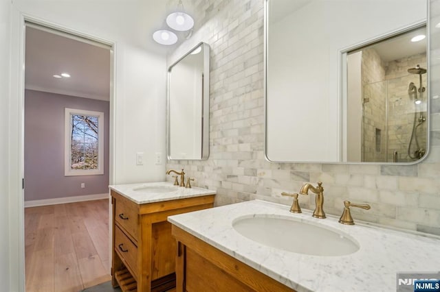 bathroom with walk in shower, vanity, hardwood / wood-style floors, and backsplash