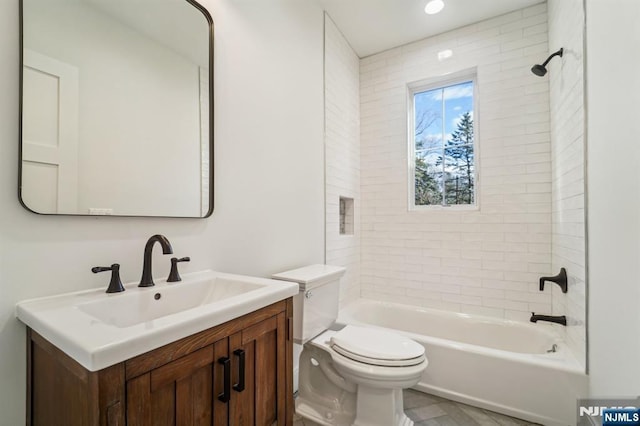 full bathroom featuring vanity, toilet, and tiled shower / bath