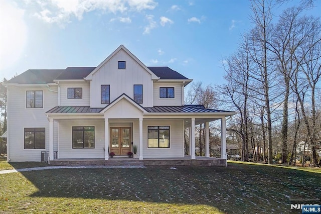 modern farmhouse style home featuring covered porch and a front lawn