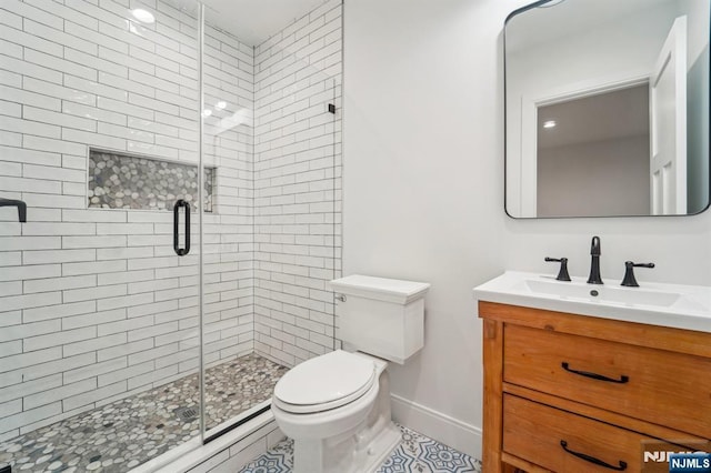 bathroom featuring vanity, toilet, and a shower with shower door