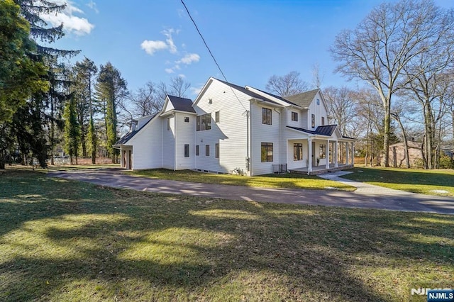 view of side of property with a porch and a yard