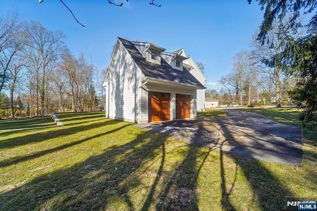 view of side of home featuring a garage and a yard