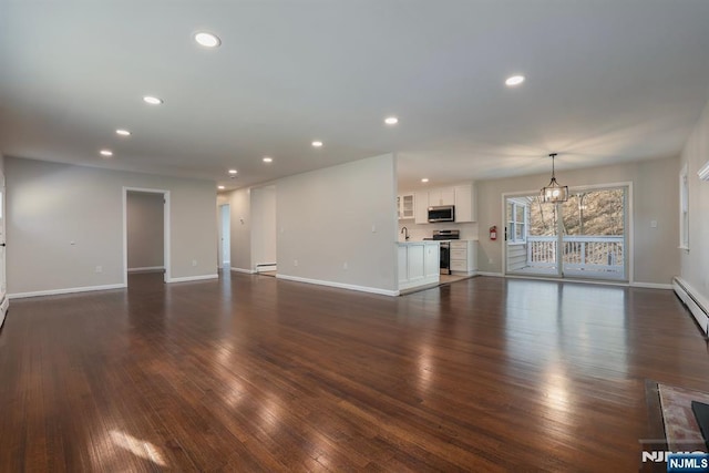 unfurnished living room featuring dark wood-type flooring, sink, and a notable chandelier